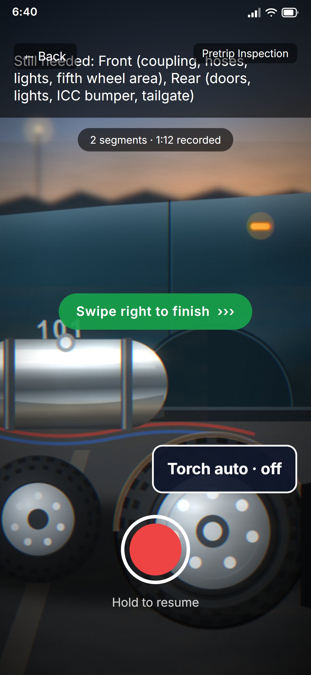 The pre-trip capture screen, paused between segments: the bar lists what is still needed — the front and the rear of the tractor — two segments and 1:12 are recorded, and the press-and-hold record button sits under a swipe-right-to-finish hint.